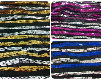 May include: Close-up of four fabric swatches with silver and colored sequins arranged in horizontal stripes. The swatches are gold, pink, blue, and silver.