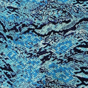 May include: A fabric featuring a repeating snakeskin pattern in shades of bright blue, light cyan, and deep black. The design consists of interconnected, scale-like shapes that create a textured, organic appearance across the entire surface.