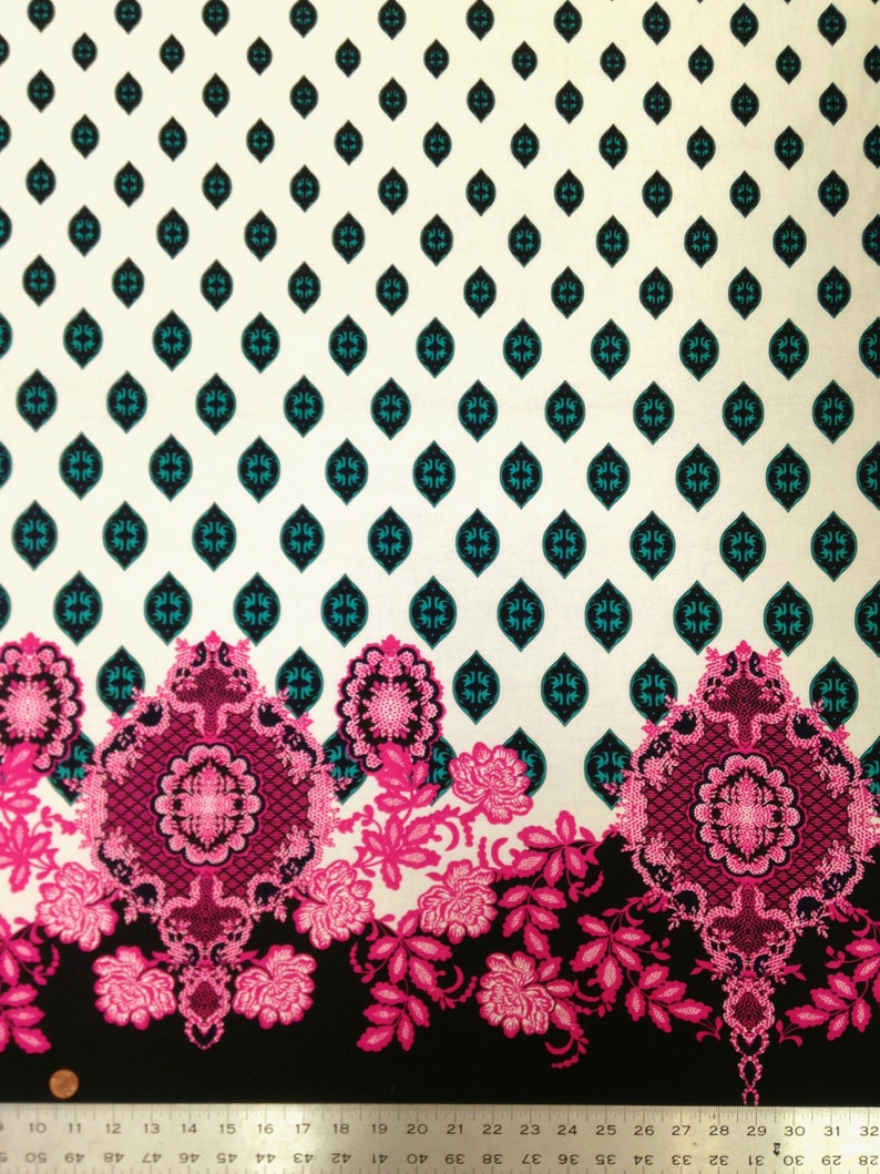 May include: White fabric with a repeating pattern of teal blue and black diamond shapes. The bottom of the fabric features a black background with a pink and white floral design.