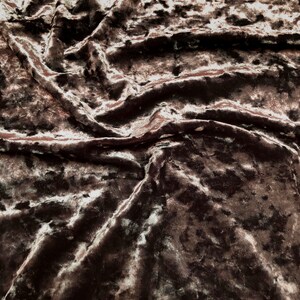 May include: Close-up of a brown crushed velvet fabric with a subtle shimmer. The fabric has a textured, slightly bumpy surface. The text "CV-BROWN" is visible in the top right corner of the image.