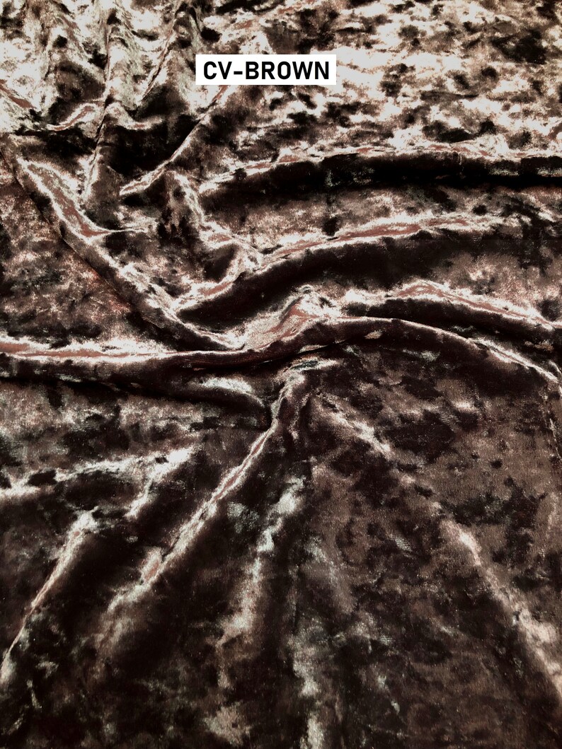 May include: Close-up of a brown crushed velvet fabric with a subtle shimmer. The fabric has a textured, slightly bumpy surface. The text "CV-BROWN" is visible in the top right corner of the image.
