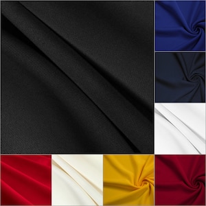 May include: A collection of fabric swatches in various colors, including black, navy blue, white, red, yellow, and cream. The fabric has a smooth, slightly textured surface.