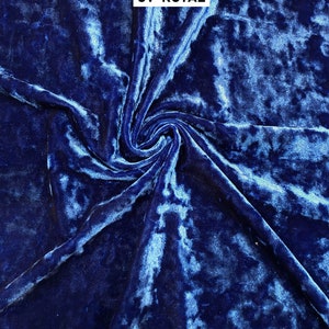 May include: Close-up of a deep blue crushed velvet fabric with a subtle shimmer. The fabric is folded and twisted, showing its texture. The text "CV-ROYAL" is printed in white on the fabric.