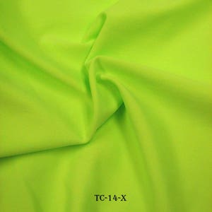 Puede incluir: Una muestra de tela verde brillante con el texto "TC-14-X" impreso en ella.