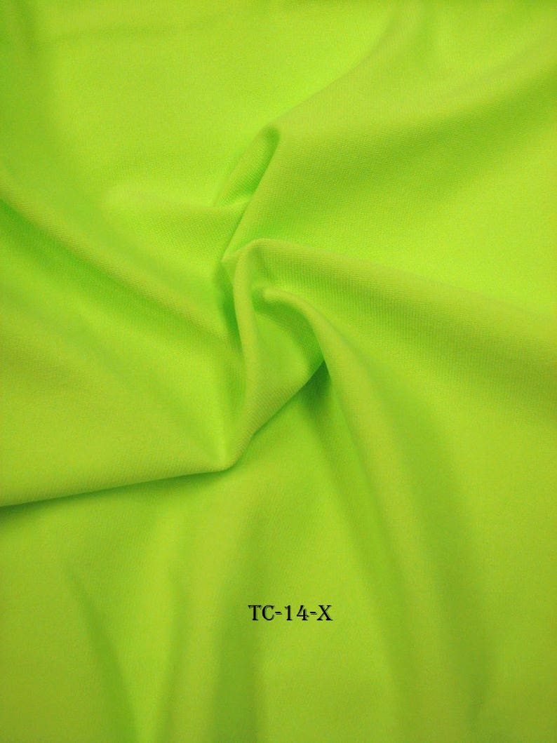 Puede incluir: Una muestra de tela verde brillante con el texto "TC-14-X" impreso en ella.