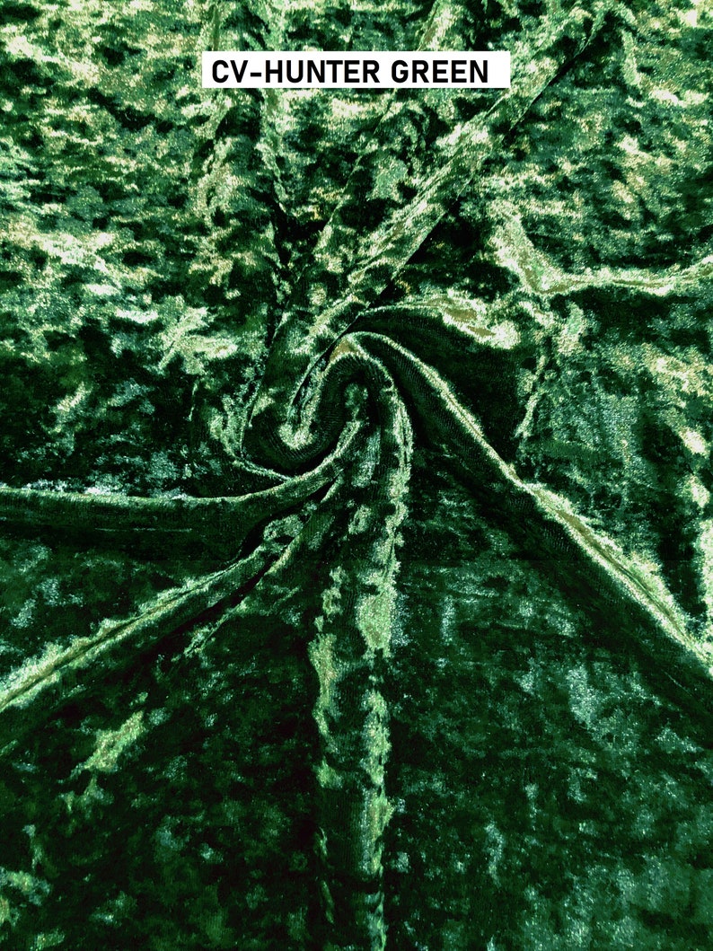 May include: Close-up of a hunter green crushed velvet fabric. The fabric has a textured, slightly shimmery surface.