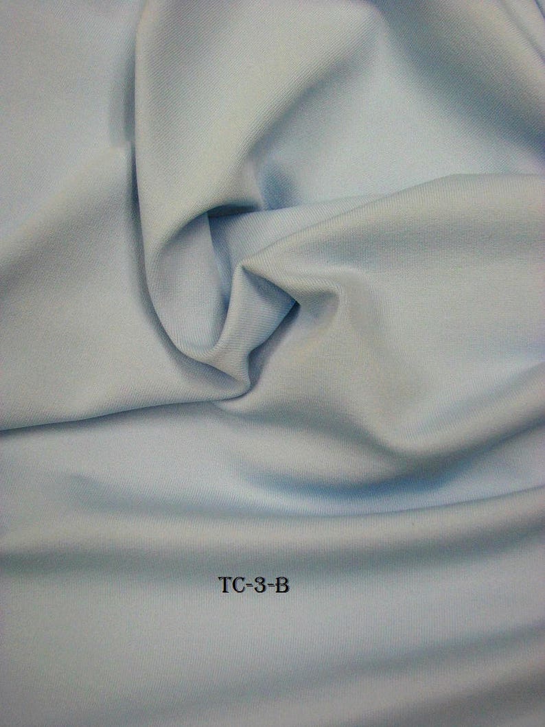 Puede incluir: Una muestra de tela azul claro con el texto "TC-3-B" impreso en ella.