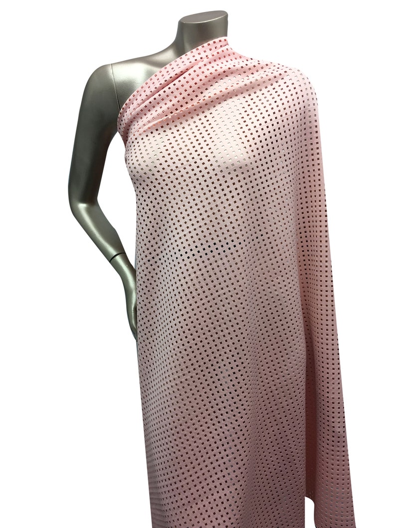 May include: Pink mesh fabric with a small square pattern. The fabric is draped over a mannequin.