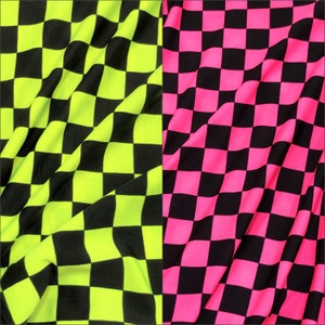 May include: Two sections of fabric with a checkered pattern. One section is neon yellow and black, the other is hot pink and black. The fabric is draped, creating soft folds and shadows, highlighting the texture and color contrast.