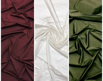 May include: Three fabric swatches in different colors: burgundy, white, and olive green. The fabric is smooth and has a slight sheen.