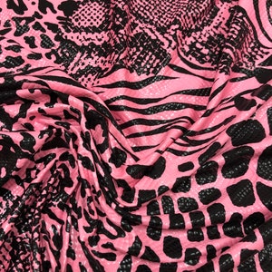 May include: Pink fabric with a black snake skin pattern.
