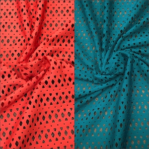 May include: Two fabric swatches with a diamond-shaped cut-out pattern. The fabric on the left is a bright coral color. The fabric on the right is a teal blue color.