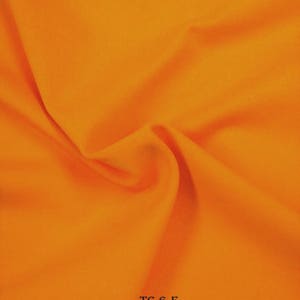 Puede incluir: Primer plano de una tela de color naranja brillante con una textura lisa. La tela est&aacute; doblada y el texto "TC-6-F" es visible en la esquina inferior derecha.