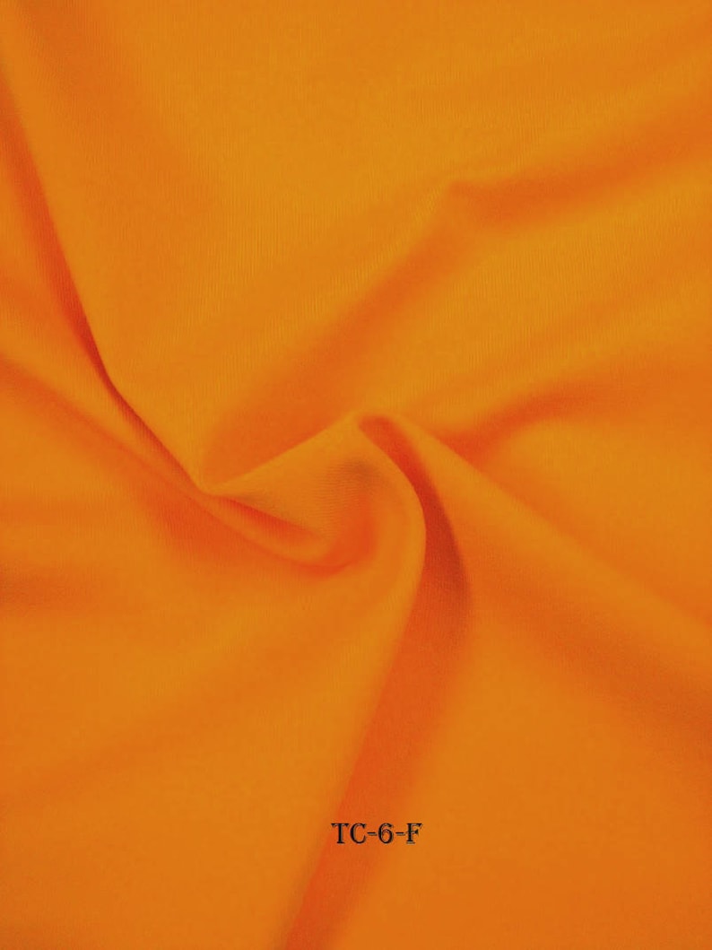 Puede incluir: Primer plano de una tela de color naranja brillante con una textura lisa. La tela est&aacute; doblada y el texto "TC-6-F" es visible en la esquina inferior derecha.