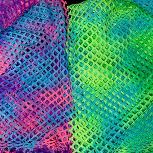 Puede incluir: Primer plano de dos secciones de tejido de tejido abierto. Una sección es una mezcla de rosa, azul y morado. La otra sección es una mezcla de verde y azul. El tejido tiene un patrón en forma de diamante.