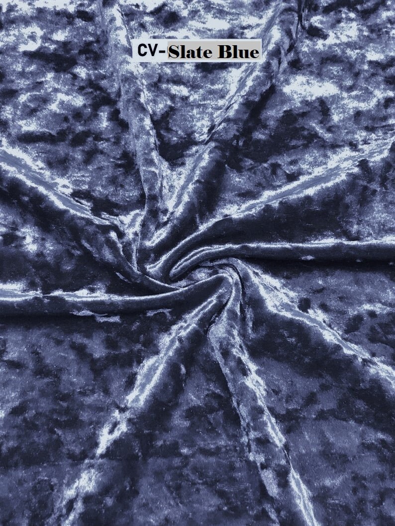 May include: Close-up of a blue crushed velvet fabric with a subtle sheen. The fabric is textured and has a soft, luxurious feel. The text "CV-Slate Blue" is visible in the top centre of the image.