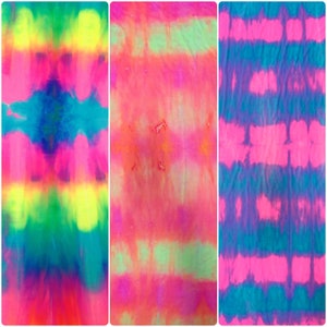 Könnte beinhalten: Drei Batik-Stoffmuster in verschiedenen Mustern. Das erste Muster ist ein hellblaues, grünes, gelbes und pinkfarbenes Batik mit einer dunkleren blauen Mitte. Das zweite Muster ist ein pinkfarbenes, orangefarbenes und grünes Batik mit einer helleren pinkfarbenen Mitte. Das dritte Muster ist ein blaues, pinkfarbenes und violettes Batik mit einer dunkleren blauen Mitte.