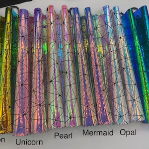 Puede incluir: Primer plano de ocho l&aacute;minas de vinilo iridiscente con un patr&oacute;n geom&eacute;trico. Las l&aacute;minas est&aacute;n etiquetadas como "Dragon", "Unicornio", "Perla", "Sirena", "&Oacute;palo" y "Lagarto".