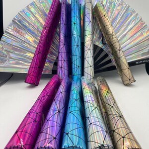 Puede incluir: Ocho portacepillos de maquillaje hologr&aacute;ficos iridiscentes con un patr&oacute;n geom&eacute;trico y costuras negras. Los portacepillos est&aacute;n dispuestos en una fila, con los extremos de los portacepillos mirando hacia el espectador. Los portacepillos son de varios colores, incluyendo rosa, morado, azul y dorado.