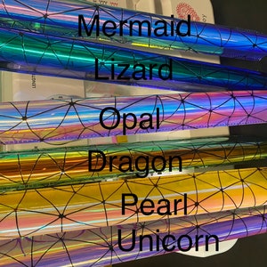 Puede incluir: Seis l&aacute;minas de vinilo iridiscente con un patr&oacute;n geom&eacute;trico y las palabras "Mermaid", "Lizard", "Opal", "Dragon", "Pearl" y "Unicorn" impresas en ellas.