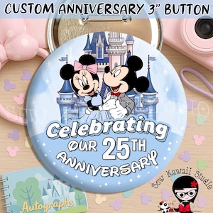 May include: A round 7.62 cm button featuring a light blue background with a castle illustration and Mickey and Minnie Mouse. The text reads Celebrating Our 25th Anniversary. The button has a metallic pin back and a glossy finish on the front surface.