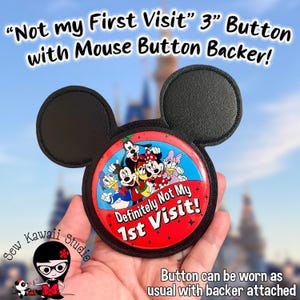May include: A 3-inch button with a mouse ear-shaped backer. The button features a red background with the text "Definitely Not My 1st Visit!" and cartoon characters. The button can be worn as usual with the backer attached.