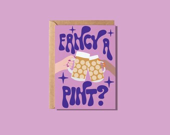 May include: Greeting card with a purple background and the words "Fancy a Pint?" in blue. The card features two hands toasting beer mugs. The card is in a brown envelope.