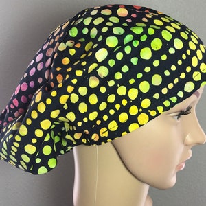 May include: A black scrub hat with a colorful polka dot pattern. The dots are yellow, green, orange, and pink.