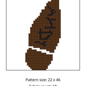 May include: A pixelated brown design with black text, likely for cross-stitch or embroidery. The pattern is a leaf shape with text inside. Finished size is 1.2 x 2.5 inches.
