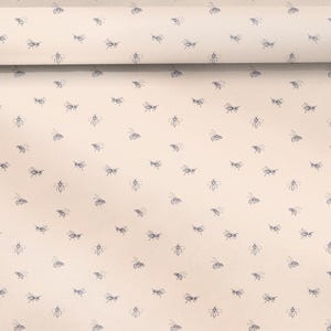 Puede incluir: Tela beige con un patrón repetido de pequeñas abejas azules estilizadas. La tela está enrollada, mostrando el patrón en toda la superficie. Ideal para proyectos de costura y decoración.