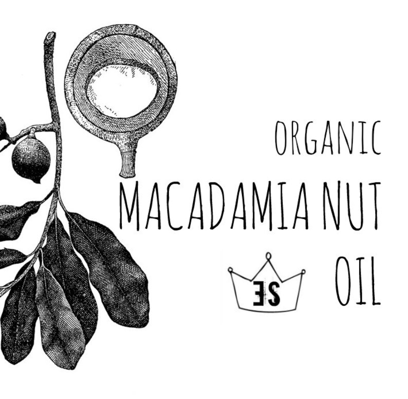 Peut inclure: Illustration en noir et blanc d'huile de noix de macadamia. L'image pr&eacute;sente un dessin d&eacute;taill&eacute; d'une noix de macadamia, une branche avec des feuilles et des noix, et les mots "Organic Macadamia Nut Oil". Un logo de couronne est &eacute;galement inclus.