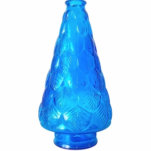 Puede incluir: Una botella decorativa de vidrio azul vibrante con forma de árbol. La botella presenta un patrón de hojas texturizadas y una base redonda. La botella mide aproximadamente 25 cm de altura.