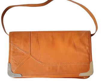 May include: A brown leather shoulder bag with a flap closure and silver hardware. The bag has a geometric design and is made of a textured leather.