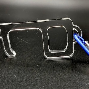 May include: A clear acrylic key-shaped tool with a blue carabiner clip. The tool has two loops and a small rectangle for opening doors and pushing buttons.