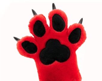 May include: A red plush paw with black claws and a black paw print in the center. The paw is designed to look like an animal's paw.