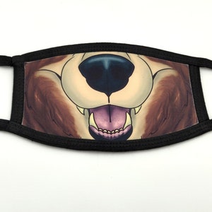 Könnte beinhalten: Schwarze Stoffmaske mit einem braunen und weißen Fell-Maul-Design. Die Schnauze hat eine schwarze Nase und eine rosa Zunge mit weißen Zähnen.