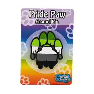 May include: A green, white, and gray paw print enamel pin on a card with the text "Pride Paw Enamel Pin" and a paw print logo for Fursuit Supplies.