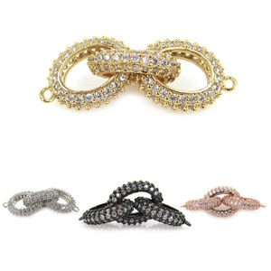 May include: Gold, silver, and rose gold tone double circle connector with clear cubic zirconia stones. The connector is a popular choice for jewelry making and can be used to connect necklaces, bracelets, and other jewelry pieces.