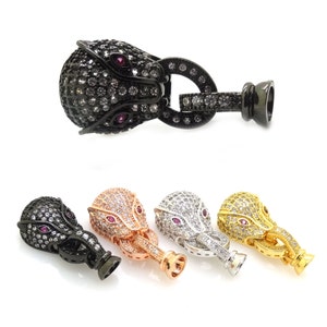 May include: Four different colored metal clasps with a panther head design. The clasps are adorned with clear and pink rhinestones. The clasps are black, rose gold, silver, and gold.