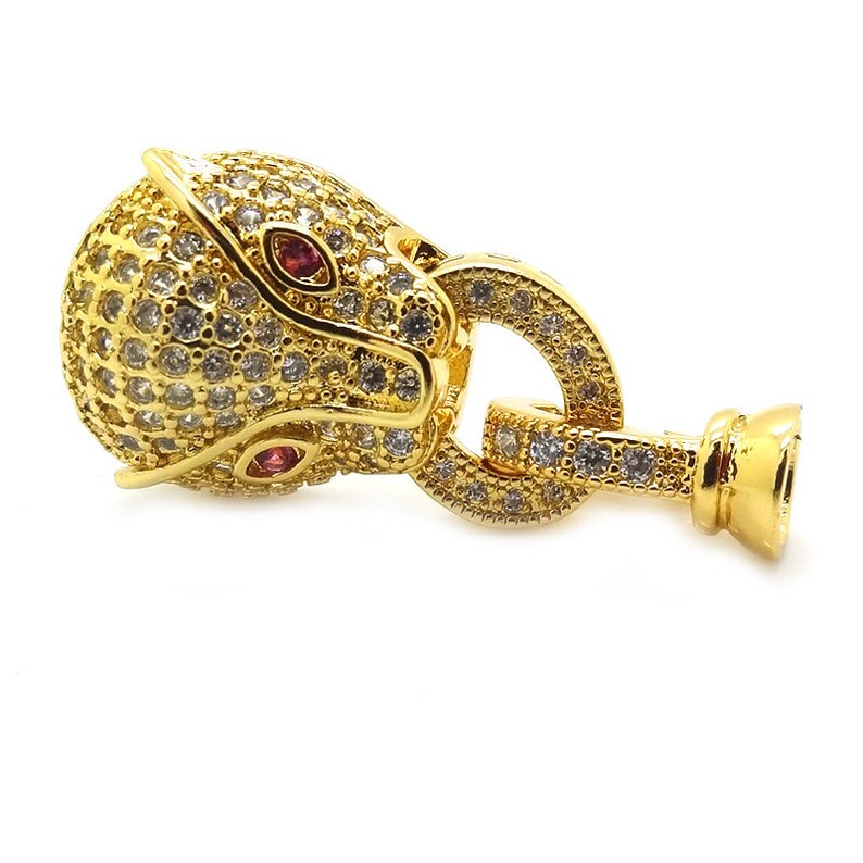 May include: Gold-tone clasp with a detailed animal head design, featuring clear and red rhinestones. The clasp has a round ring and a small, round end cap.