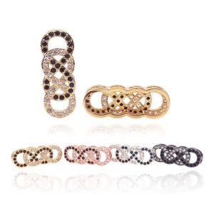 Puede incluir: Un conjunto de cinco conectores de cadena de oro, oro rosa, plata y negro con piedras de circonita cúbica transparentes y negras. Los conectores están diseñados para ser utilizados en la fabricación de joyas.