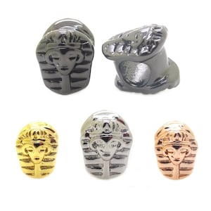 May include: Five charm beads in different colors, each featuring a detailed design of an Egyptian pharaoh's head. The beads are made of metal and have a shiny finish.