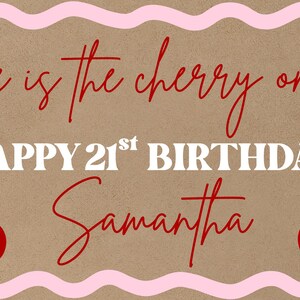 May include: A brown background with a pink wavy border. The text "She is the cherry on top! Happy 21st Birthday Samantha" is written in red and white. Two red cherries with green stems are on each side of the text.