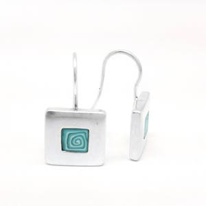 Puede incluir: Pendientes de aro de plata con un colgante cuadrado con un diseño de espiral azul turquesa.
