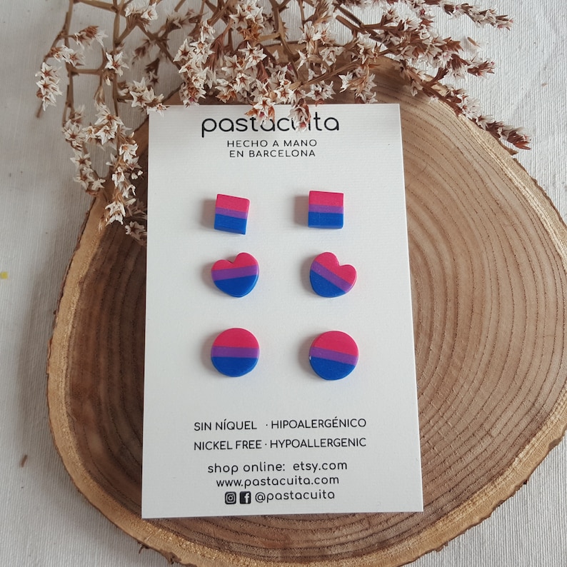 May include: A set of six earrings featuring different shapes and sizes in blue, pink, and purple. The earrings are made of polymer clay and are nickel-free and hypoallergenic. The text on the card reads "pastacuita", "HECHO A MANO", "EN BARCELONA", "SIN N&Iacute;QUEL HIPOALERG&Eacute;NICO", "NICKEL FREE HYPOALLERGENIC", "shop online: etsy.com", "www.pastacuita.com", and "@pastacuita".