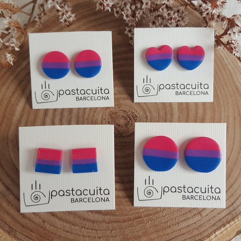 May include: Four pairs of bisexual pride earrings on white cards with the text "pastacuita BARCELONA". The earrings are in the shape of a circle, heart, and square.