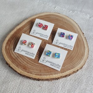May include: Four pairs of colorful mosaic tile earrings on white cards with the text "pastacuita BARCELONA".