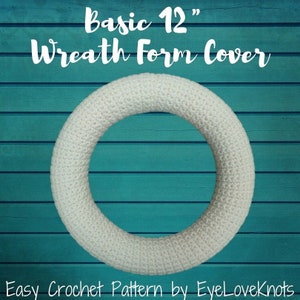 Op de afbeelding: Een witte gehaakte kransvormhoes voor een krans van 30 cm. De kransvorm bevindt zich op een tealblauwe houten achtergrond. De tekst "Basic 12" Wreath Form Cover" staat bovenaan de afbeelding. De tekst "Easy Crochet Pattern by EyeLoveKnots" staat onderaan de afbeelding.