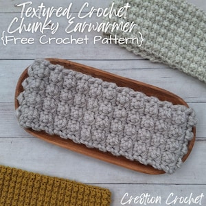 May include: A gray textured crochet ear warmer on a wooden tray. The ear warmer is made with a chunky yarn and has a raised stitch pattern. The text "Textured Crochet Chunky Earwarmer {Free Crochet Pattern}" is above the ear warmer.