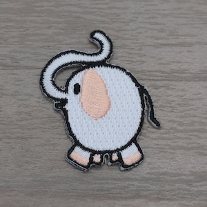 Pode incluir: Um conjunto de patches de elefante de feltro branco com contornos pretos e orelhas cor-de-rosa. Os elefantes estão em várias poses, alguns com a tromba levantada e outros com a tromba para baixo.